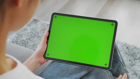close up de mujer sosteniendo en las manos una tableta digital con pantalla verde para internet en línea, pantalla chromakey para publicidad.