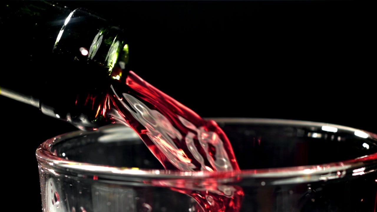Vino tinto vertiéndose en cámara lenta de la botella a la copa