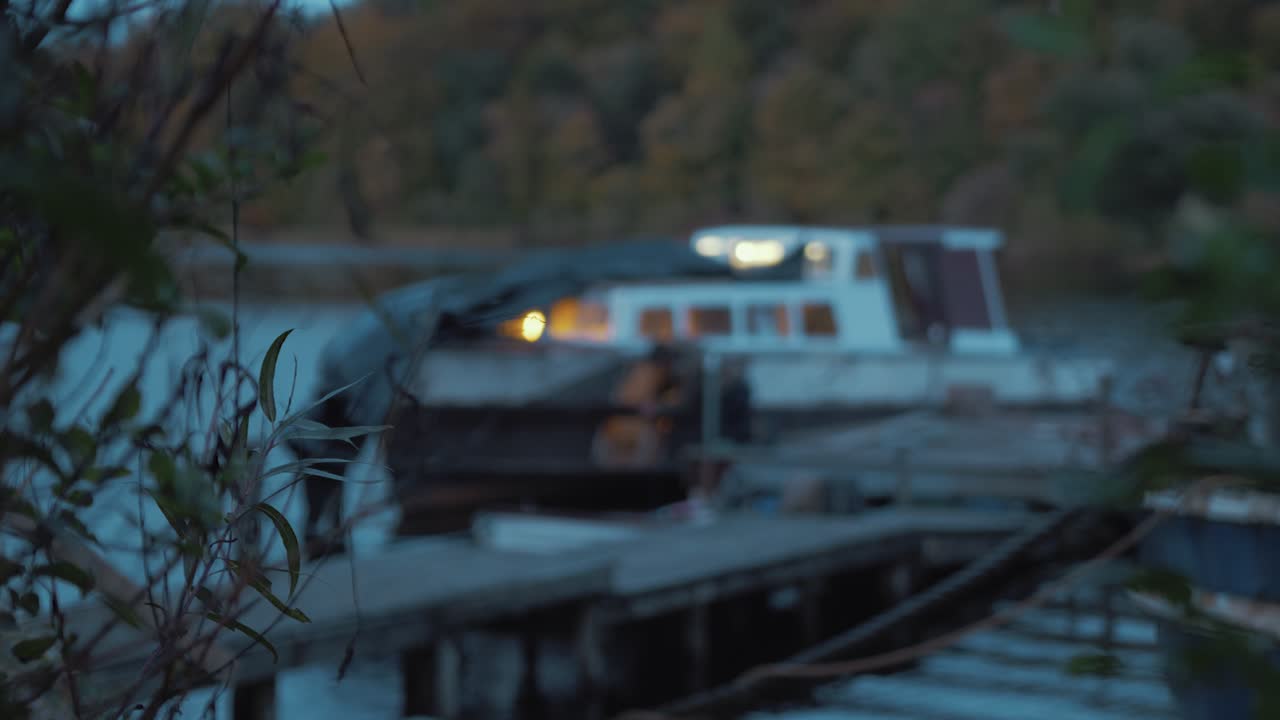 나무 보트의 뱃머리에서 판자를 수리하는 남자