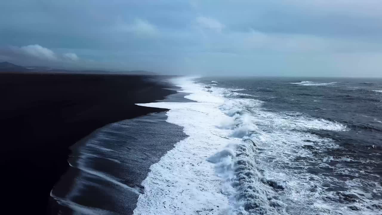 Aerial landscape view of Iceland black sand ocean shoreline, on a moody day