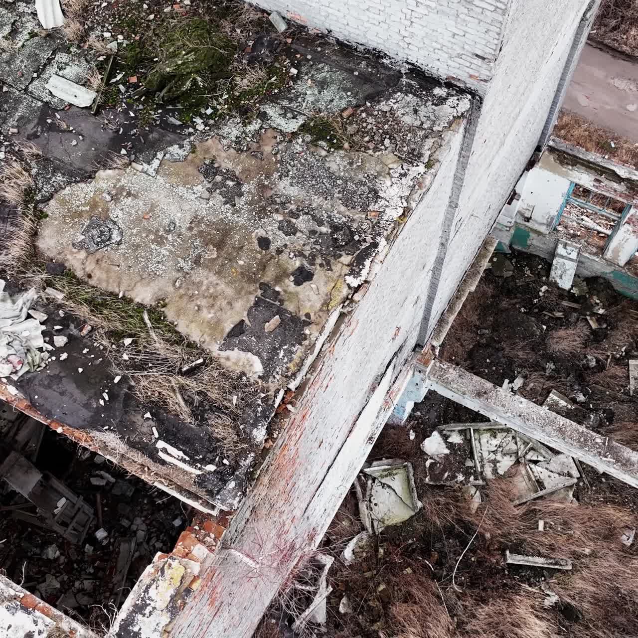 Remains of an old buildings with some broken parts. Shooting in motion on the area of an abandoned plant. Aerial perspective