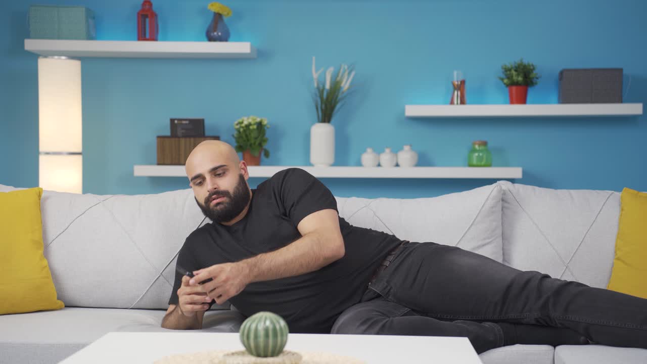 Man lying on the sofa is resting.