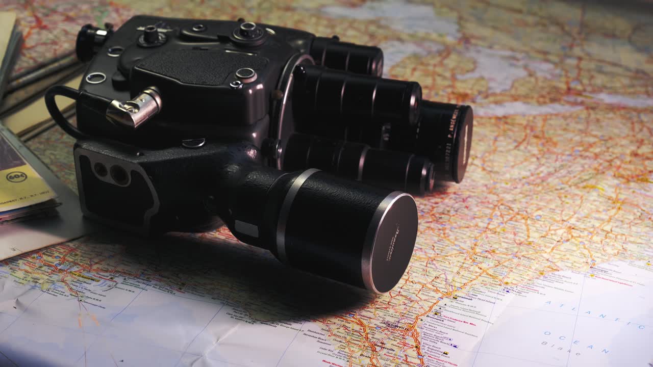 Vintage 8mm cine film camera laid on road maps evoke travel memories
