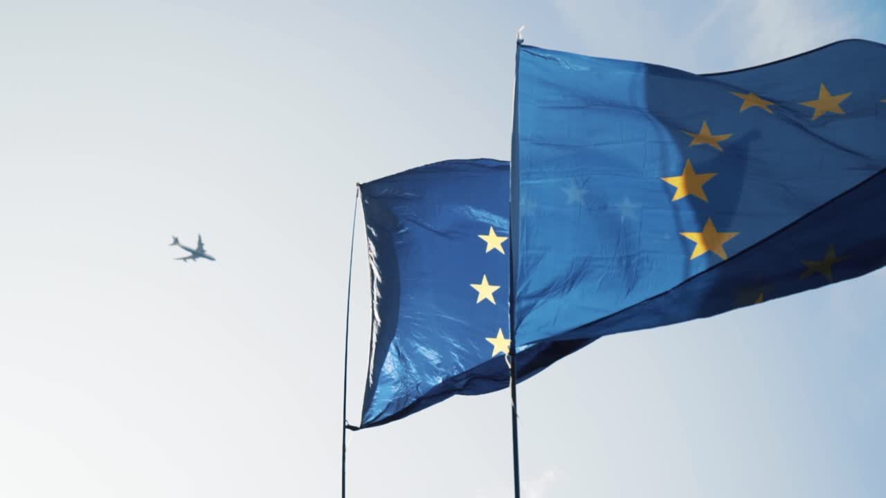 European Union Flags and Airplane in the Sky