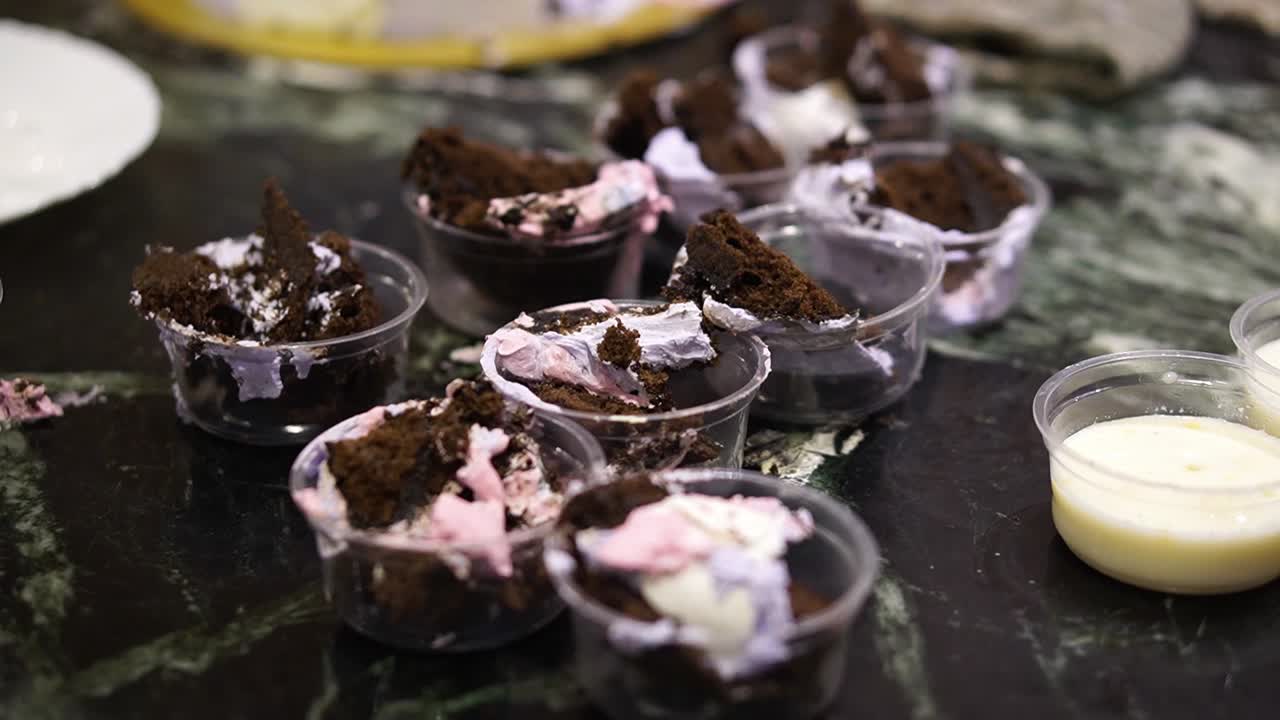 Pieces of cakes served in transparent disposable bowl.