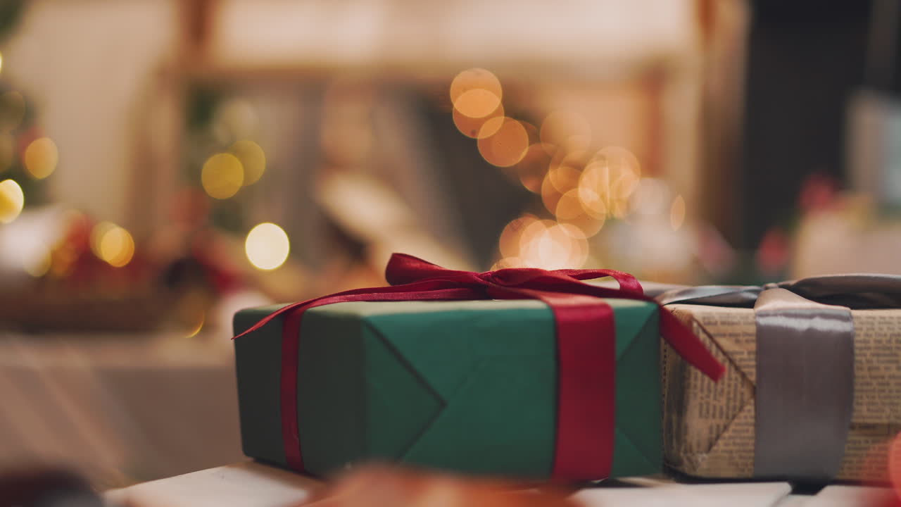 4K Hand puts wrapped gift box under the christmas tree