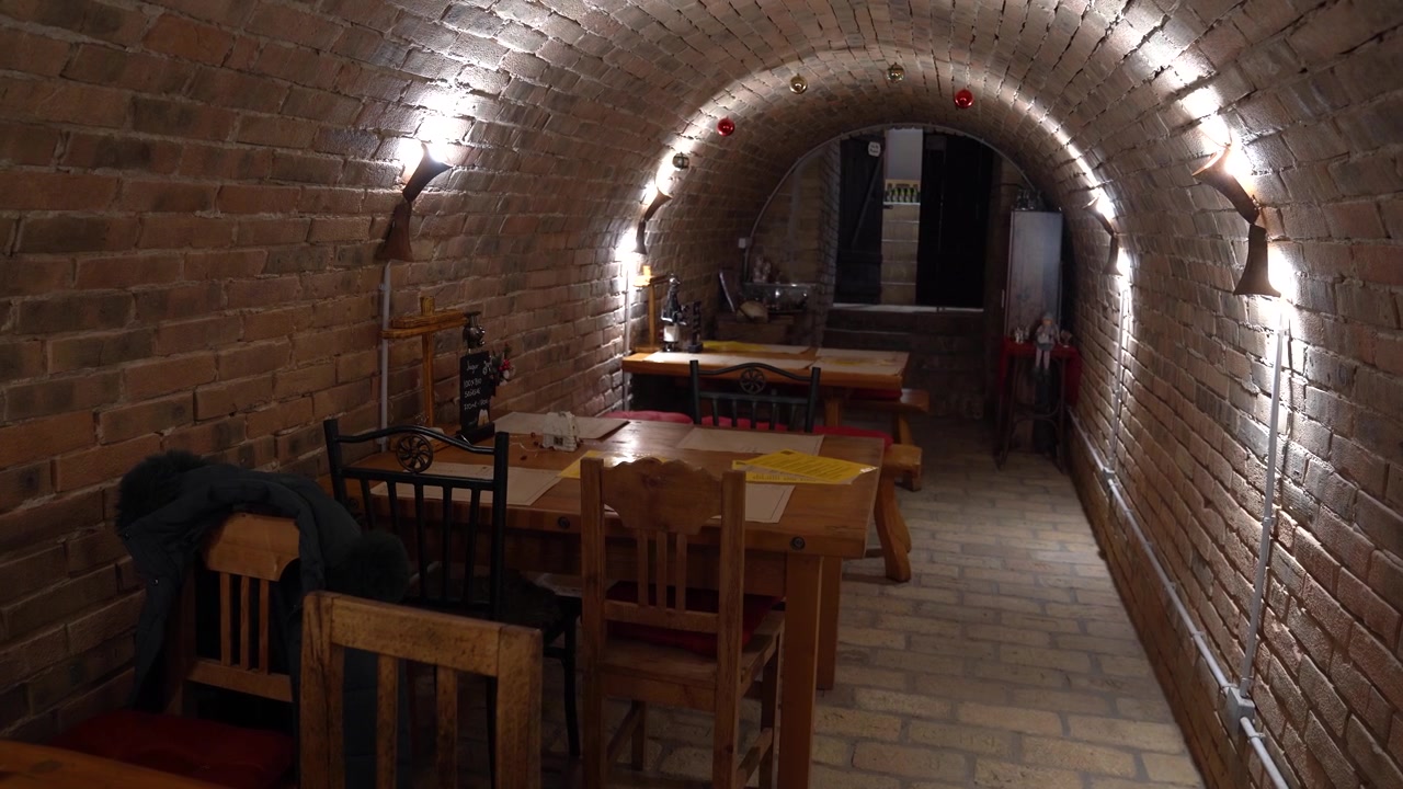 Old traditional wine cellar interior with brick walls, arched ceiling and wooden furniture