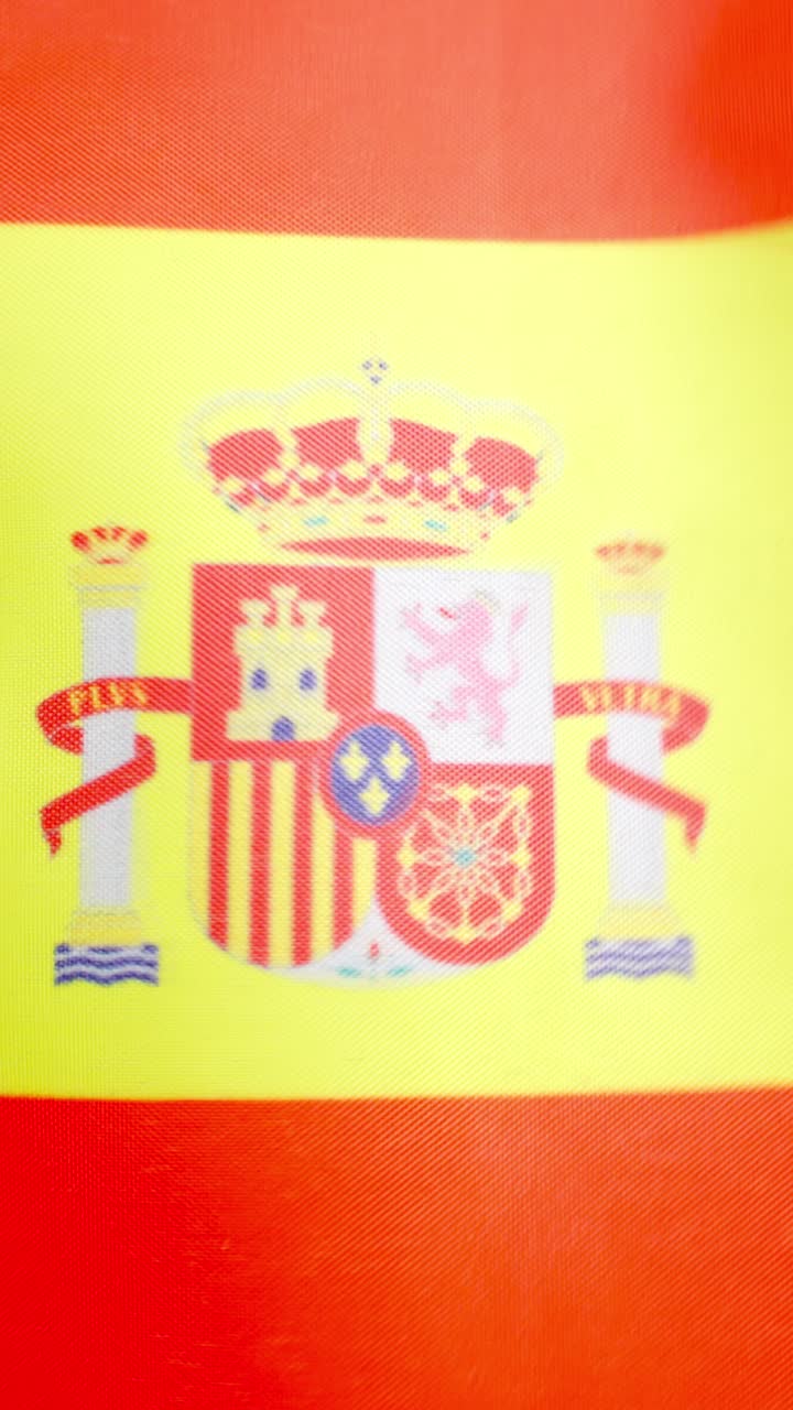 Vertical video of Spanish national flag waving by the wind