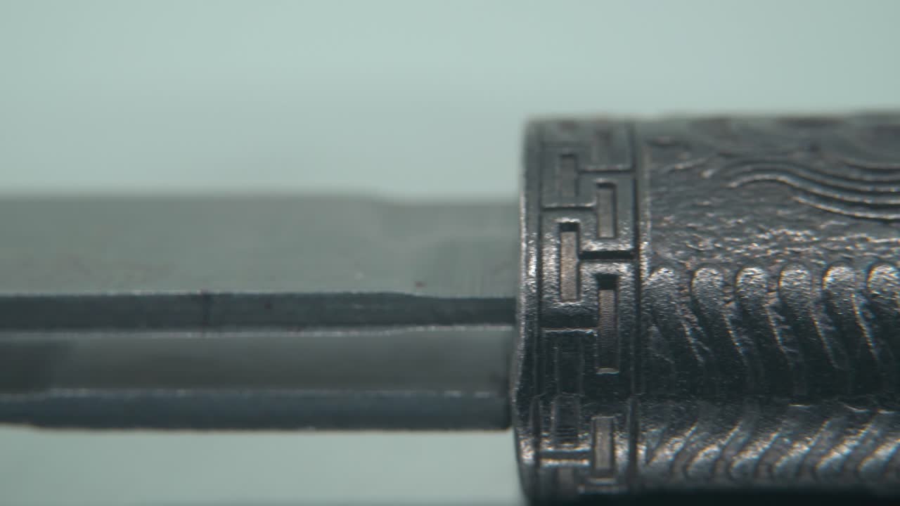un macro close-up de un antiguo cuchillo de plata, arma antigua china, cuchilla histórica de época, viejo acero decorativo, daga tradicional, iluminación profesional, panela de video 4k cinematográfica a la derecha