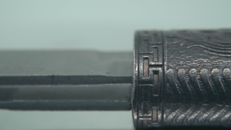 A macro close-up shot of an ancient silver knife, Chinese antique weapon, historical vintage blade, old decorative steel, traditional dagger, professional lighting, cinematic 4K video pan right