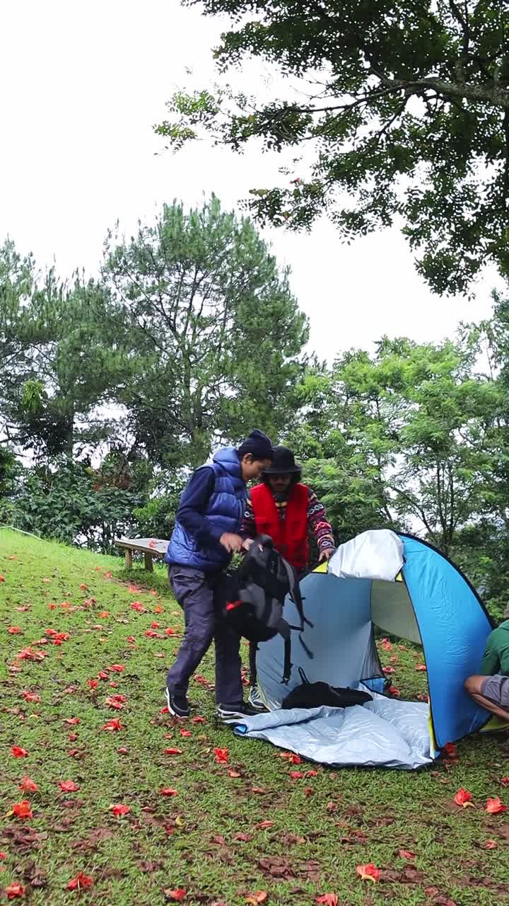 Friends greeting embracing at campsite while enjoying camping trip