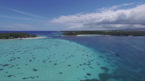 coral reef island of mauritius with speeding motor boats cruising on the crystal clear waters of the ocean on vacation