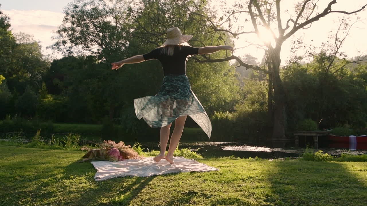 Joyful Woman Dancing - Spinning on Outdoor Picnic Blanket - Sun Flare Glow at Sunset