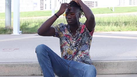 Stylish-black-hipster-man-sitting-on-stairs-in-city