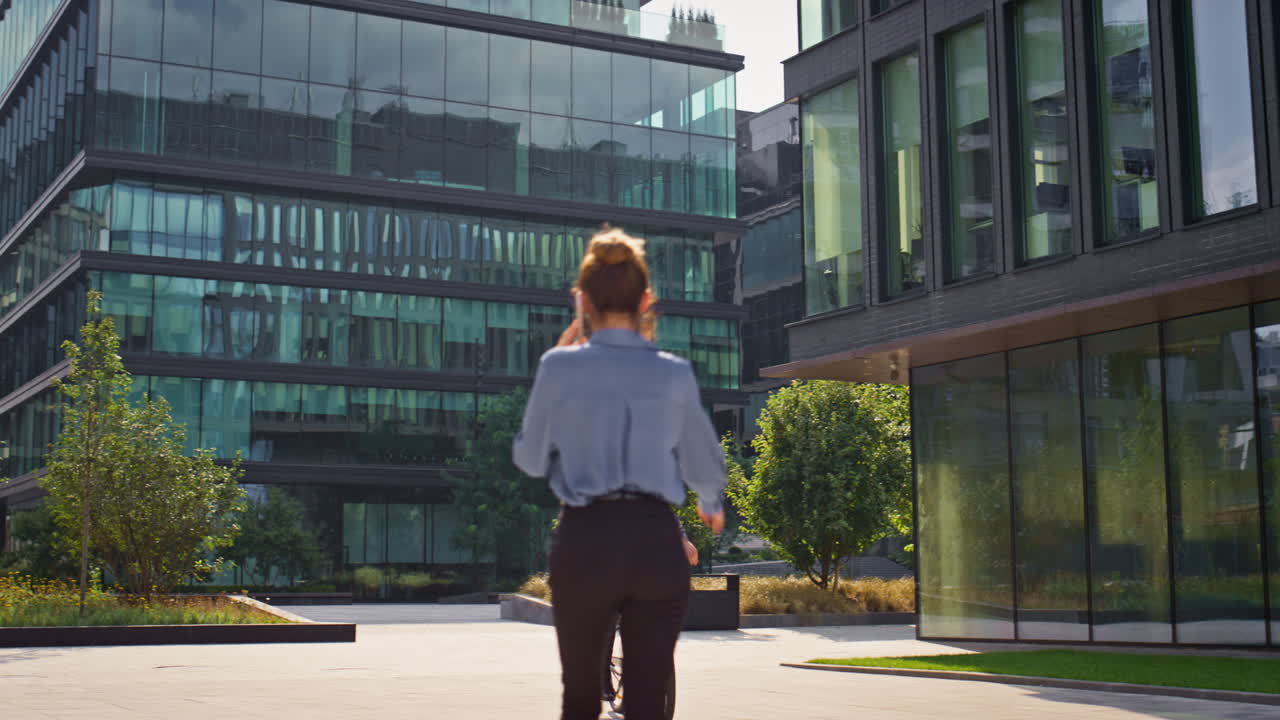 hombre de negocios alegre montando bicicleta en el centro de la oficina. hombre sonriente saludando a su colega