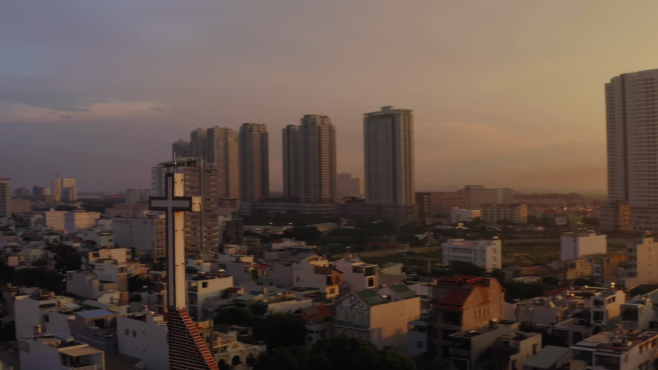 매우 늦은 따뜻하고 극적인 오후 빛 속에서 빽빽한 도시 배경에 대한 라틴 스타일의 기독교 십자가의 4k 드론 영상