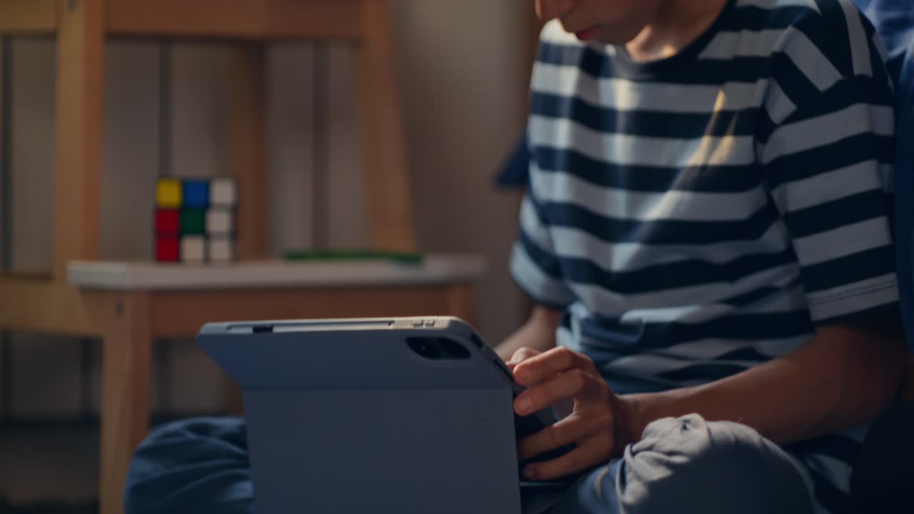 Child studying with tablet in a bedroom