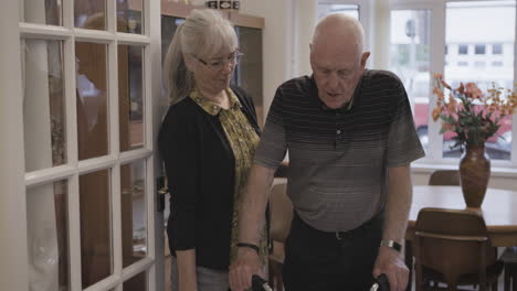 elderly man with caregiver at home using a walker
