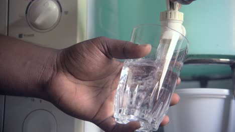 filling-glass-of-water-from-tap-blue-tank