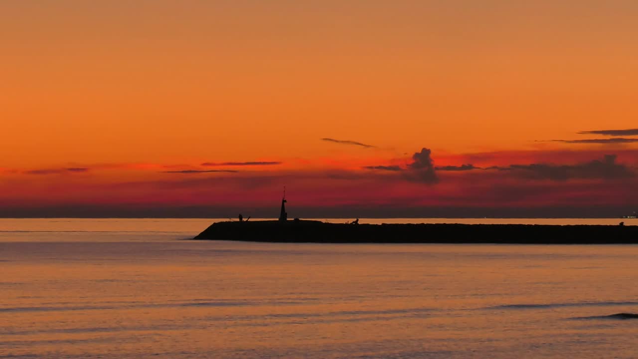 cielo nublado sobre el mar en calma y la pared del puerto, costa mediterránea de españa