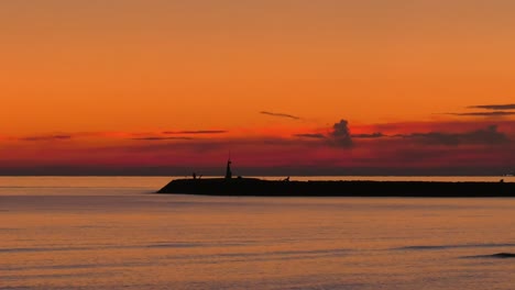 Cloudy-Dawn-sky-over-calm-sea-and-harbor-wall,-mediterranean-coast-of-Spain