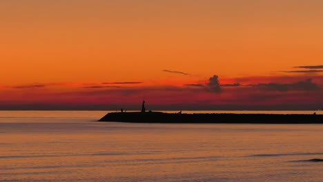 cloudy dawn sky over calm sea and harbor wall, mediterranean coast of spain