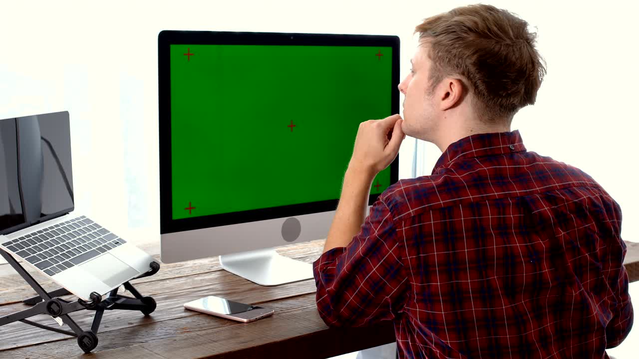 joven independiente pensando durante el trabajo con pantalla verde