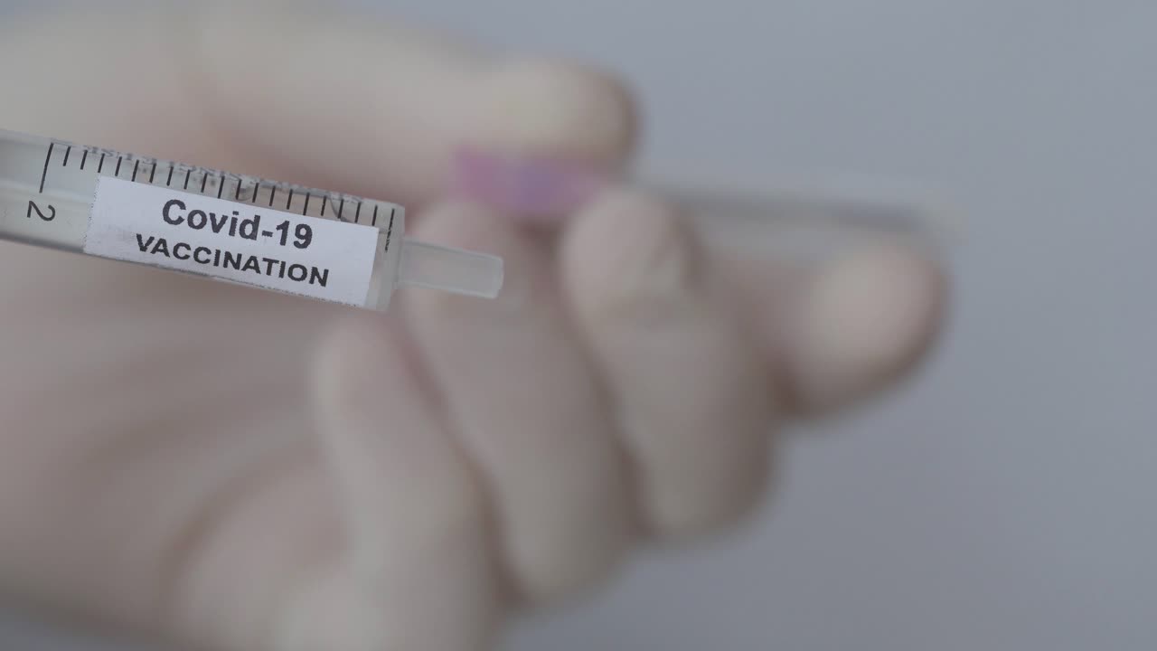 adjuntar la aguja a la jeringa con la etiqueta de vacunación covid-19 - cerrar