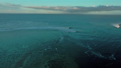 haapoti passe coral reef surfing wave boats in channel moorea french polynesia aerial drone morning sunrise lagoon south pacific ocean tahiti bora bora forward pan up motion