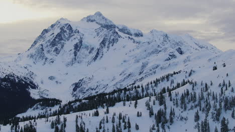 drone tilt up dolley shot of the high mount baker at winter time