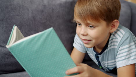 boy reading a book on a couch