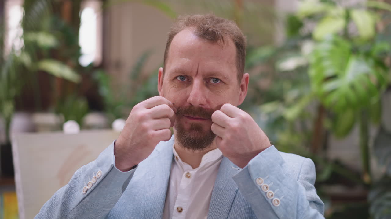 художник фиксирует усы на шезлонге. творческий художник стоит против живописи в художественной студии во время процесса рисования. стиль с творческим выражением