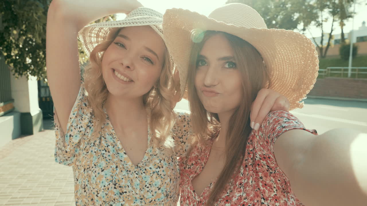 두 친구가 야외에서 셀피를 찍고 있다