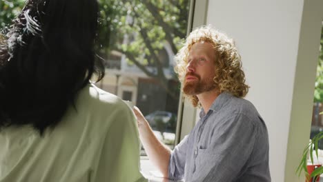 Happy-diverse-couple-drinking-coffee-and-talking-in-cafe