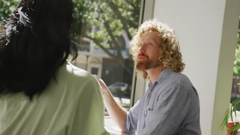una pareja feliz y diversa bebiendo café y hablando en un café.