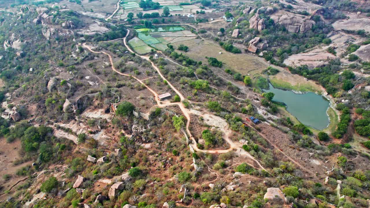 Rachakonda fort urban park with crop fields land and lake. day time, push in, tilt up,drone shot, 4k.