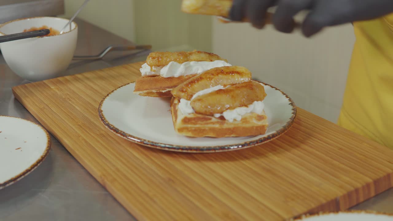 요리사 는 바나나 와 소시지 를 들인 와플 샌드위치 를 준비 하고 있다