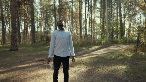 man in a forest holding a mask