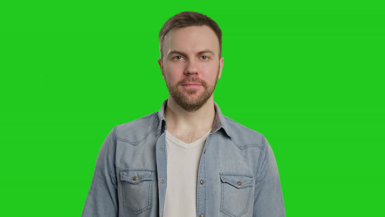 Mand smiler og giver tommelfinger op. Mand kigger ind i kameraet. Skægget mand ved chroma key.