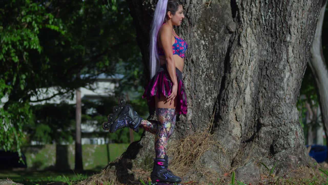 mujer bonita en el parque usando patines y una minifalda en un día soleado