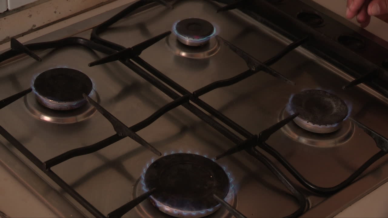 가스 라이터가 주방 스토브의 버너 4개에 불을 붙입니다.