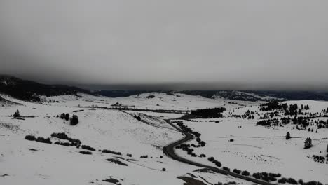 Drone-shot-of-thick-winter-clouds-and-a-windy-country-road