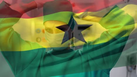 Digitale-Komposition-Der-Ghanaischen-Flagge,-Die-Im-Krankenhaus-Gegen-Eine-Chirurgin-Mit-Gesichtsmaske-Winkt