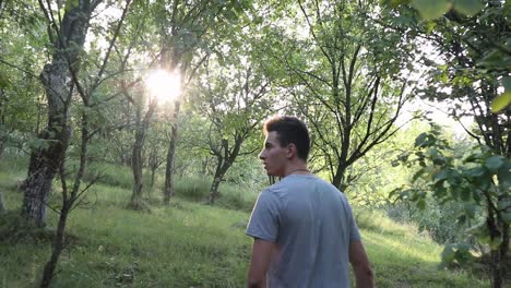 un hombre camina por un sendero en el bosque, durante el día, temporada de verano