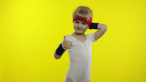 Happy-cute-girl-in-white-sportswear-showing-thumb-up-gesture-isolated-on-yellow-background.-Fitness