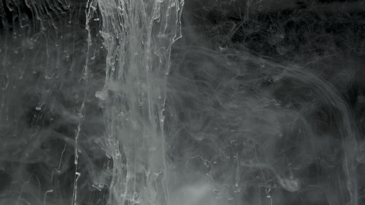 efecto de tinta blanca en agua filmado sobre fondo negro