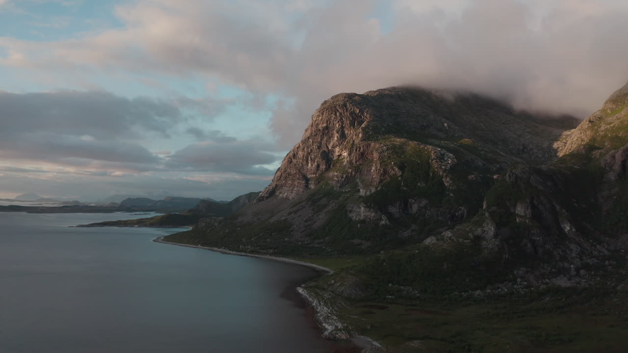 Coastal mountain landscape at Dønna in soft light from the early midnight sun captured by drone