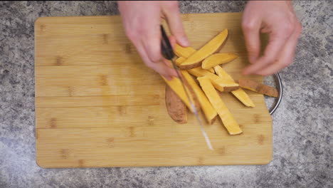 cutting sweet potato fries on a cutting board