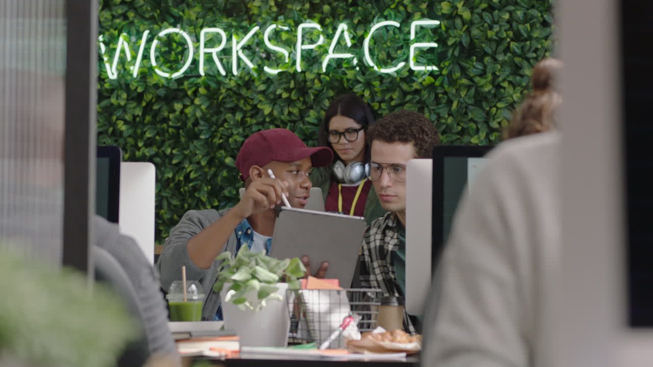 jóvenes empresarios multiétnicos que trabajan en una oficina moderna ocupada usando tabletas digitales compartiendo información colegas colaborando trabajo en equipo exitoso