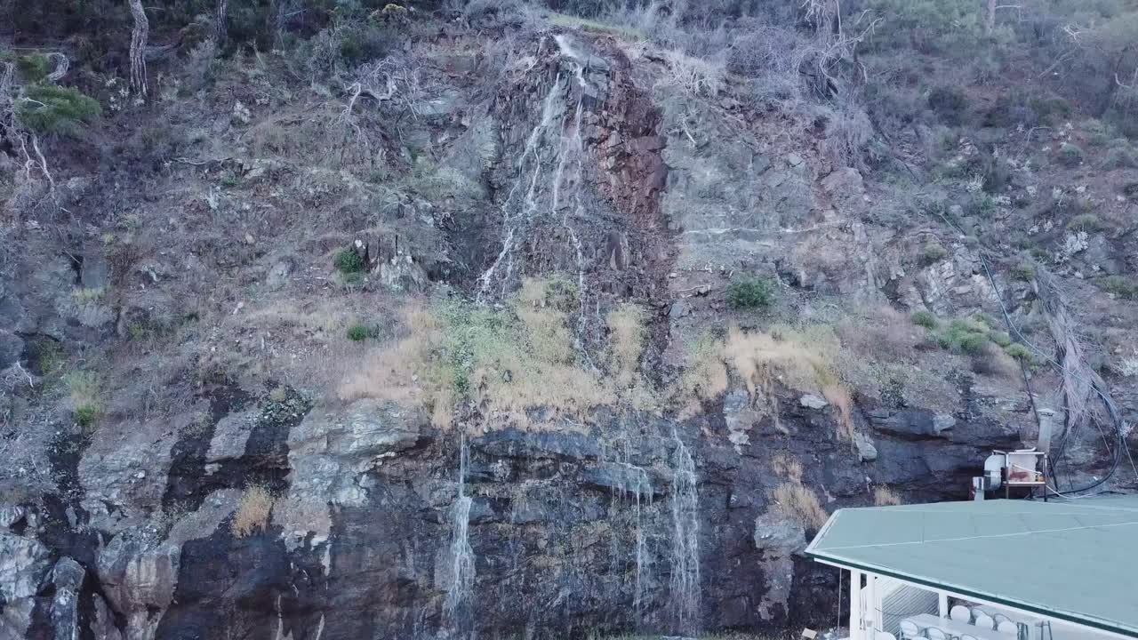 바위 가 있는 언덕 아래 로 떨어지는 폭포